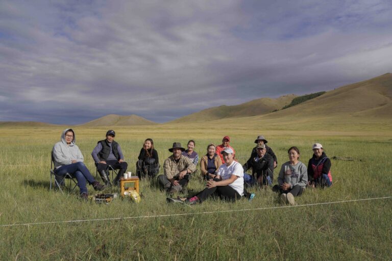 Participants in the Mongolian PLUS Project sit in a pasture